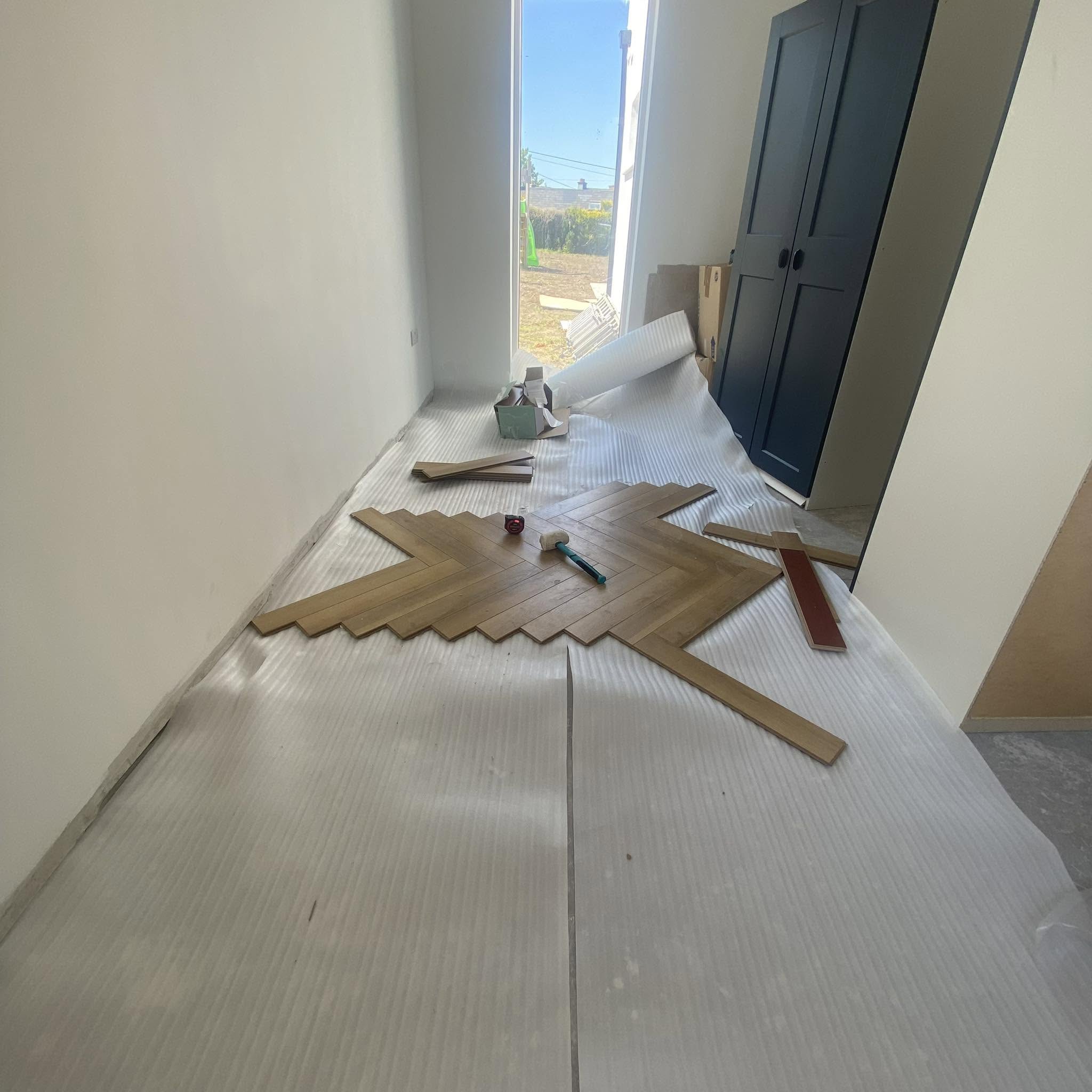 Herringbone laminate floor being laid